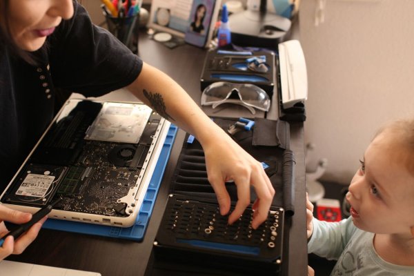 A woman and child repair a laptop